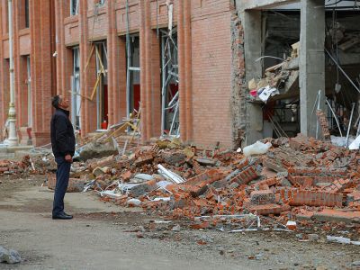 Мужчина смотрит на здание, поврежденное в результате обстрела во время военного конфликта из-за непризнанного Нагорного Карабаха, в городе Гянджа, Азербайджан, 6 октября 2020 года. Фото: Aziz Karimov / Reuters
