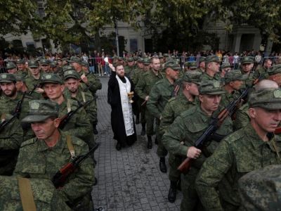 Православный священник проводит службу по призывникам-резервистам во время церемонии их отбытия на воинские части в Севастополе, Крым, 27 сентября. Фото: Alexey Pavlishak / Reuters